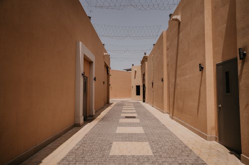 A narrow alley with a gate and barbed wire