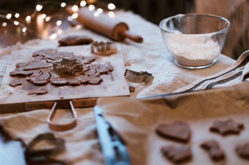 Free Atmospheric close-up of gingerbread cookie baking with star cutters, perfect for holiday inspiration. Stock Photo