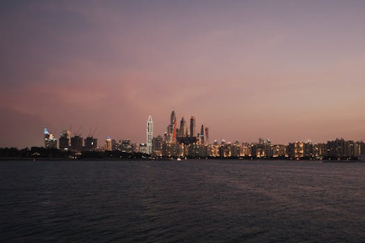 A serene view of Dubai's skyline at dusk, reflecting on the tranquil water.