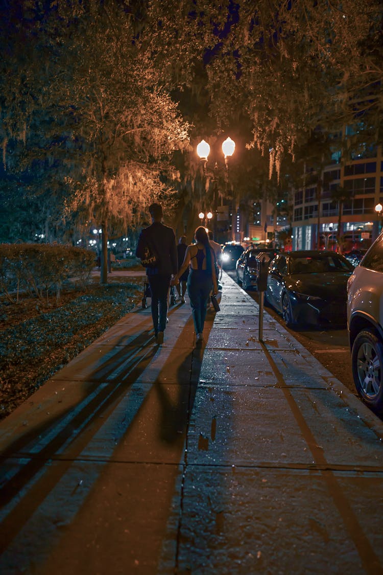 Couple Walking On Pavement On Night Street