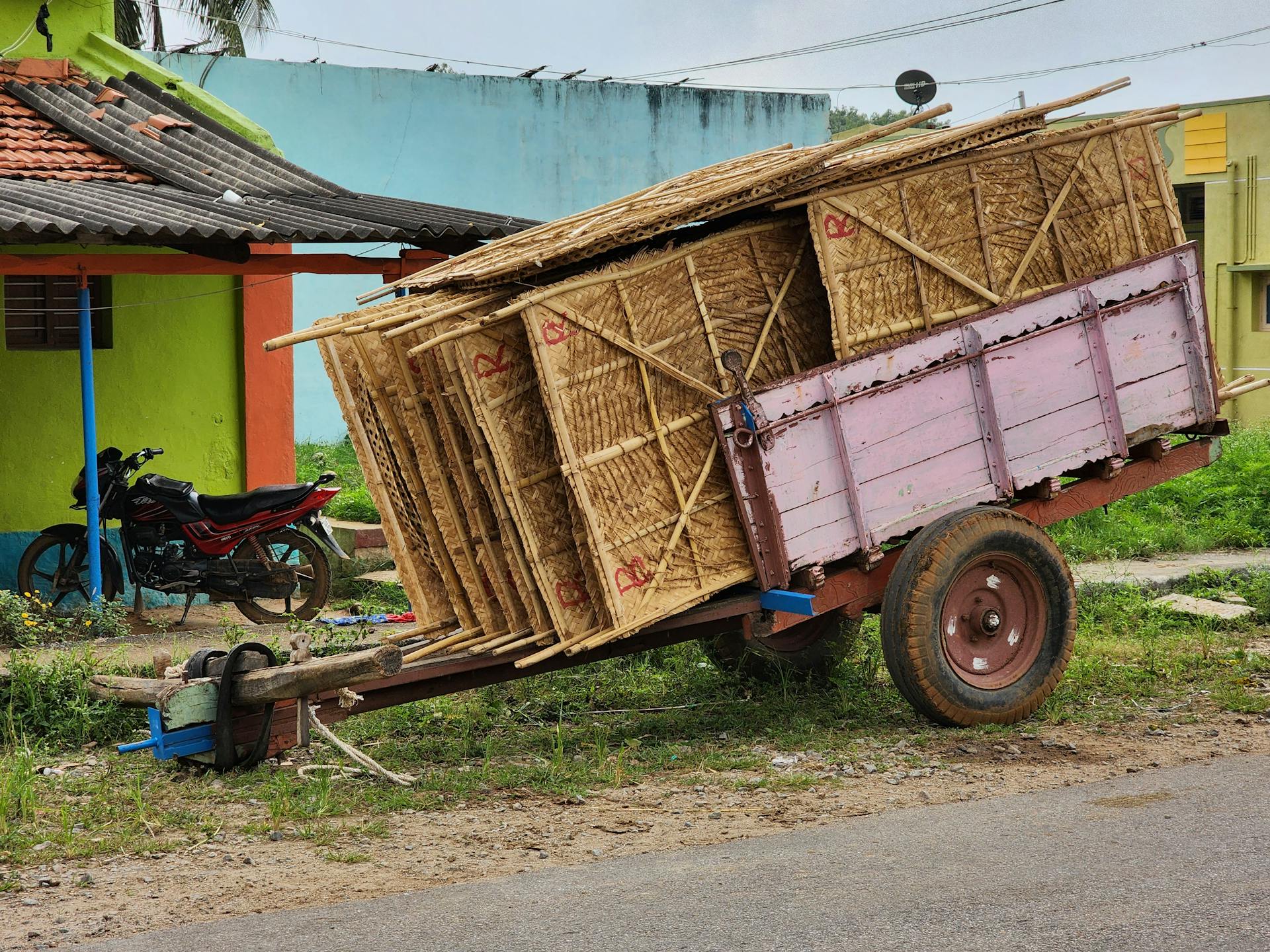 Traditional trailer loaded with straw in an Indian village setting.