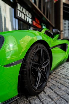 Close-up of a sleek green sports car on a cobblestone street in Dubai, showcasing luxury and speed.