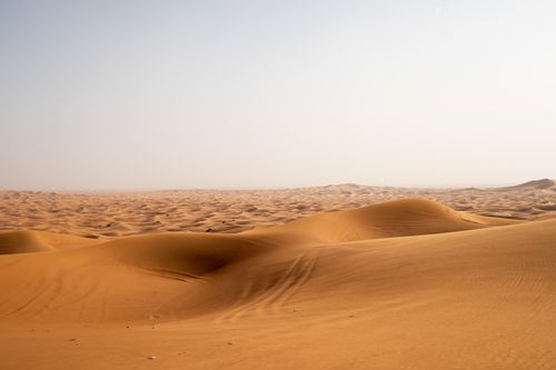 Free An endless stretch of sand dunes under a clear sky in the Dubai desert, capturing nature's vastness. Stock Photo