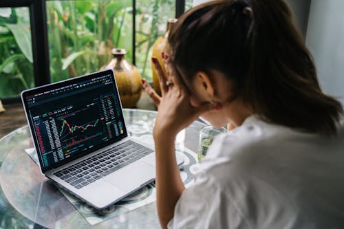 Woman Looking at Cryptocurrency Charts on Her Laptop 