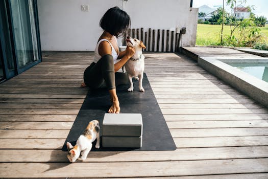 A woman stretches on a terrace with her dog and cat, enjoying a yoga session outdoors.