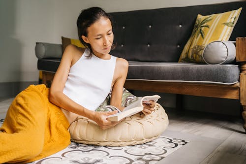 Free Young Woman Reading a Book on the Living Room  Stock Photo
