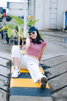 Woman in a pink top and cap posing outdoors in Cimahi, Indonesia, showcasing casual style.