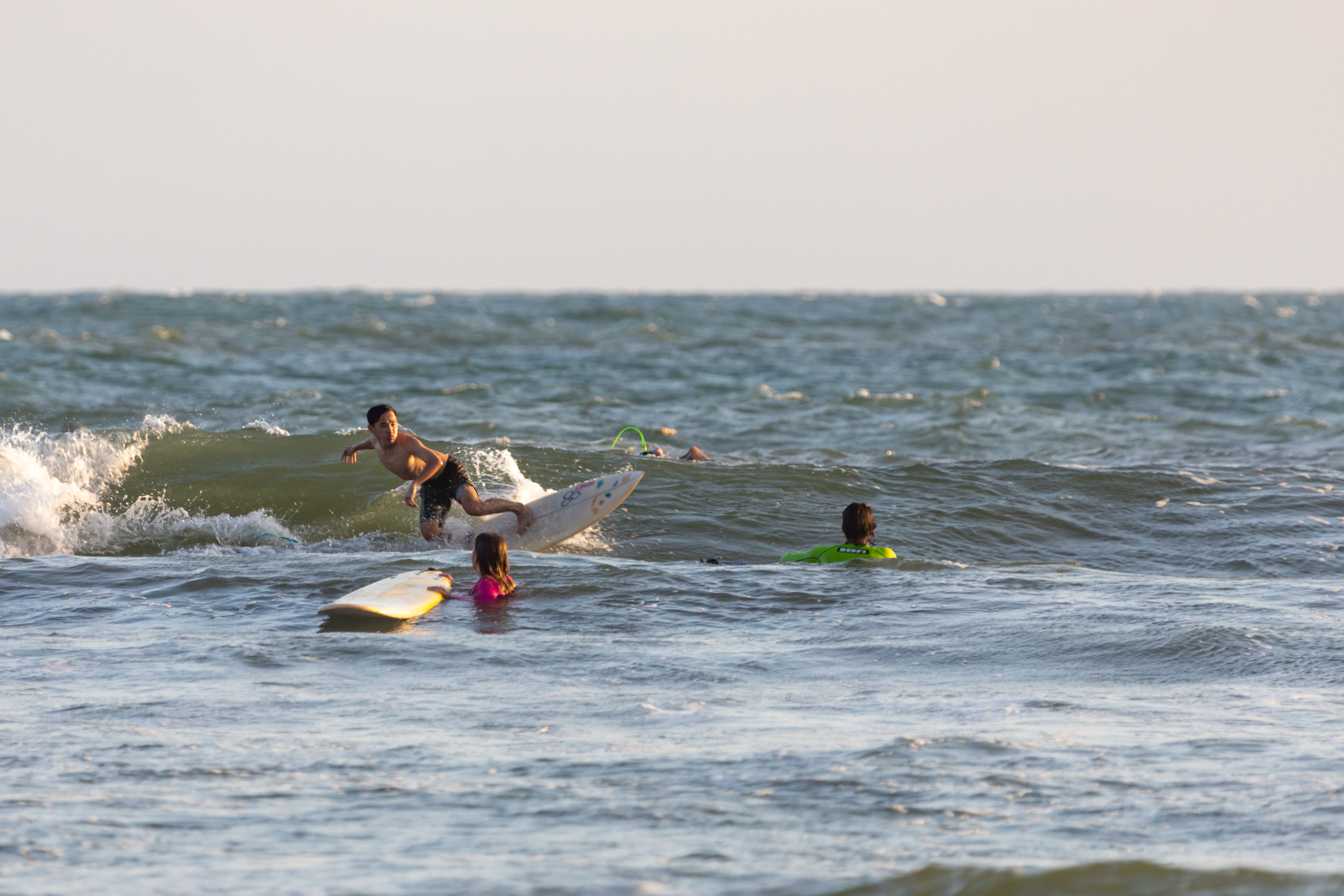 Dynamic scene of surfers catching waves on a sunny day at the ocean.