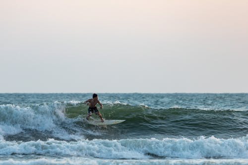 Free A Shirtless Man Surfboarding on a Sea Stock Photo