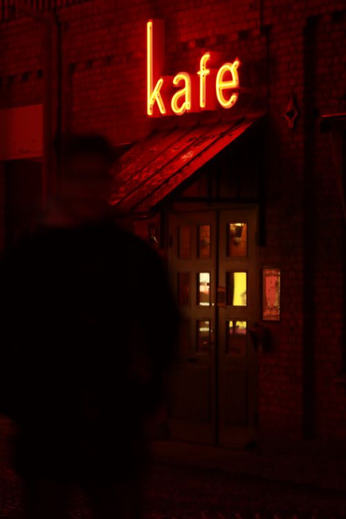Free Blurred figure at illuminated cafe doorway in Jönköping, Sweden at night. Stock Photo