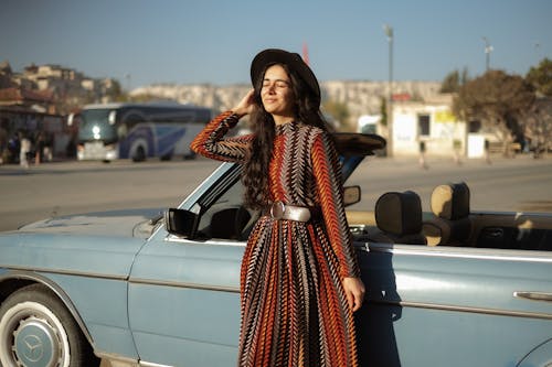 Stylish Woman Standing Beside Convertible Car