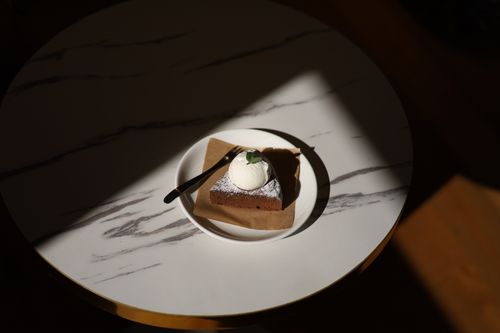 Free A rich chocolate brownie topped with vanilla ice cream on a marble table. Stock Photo