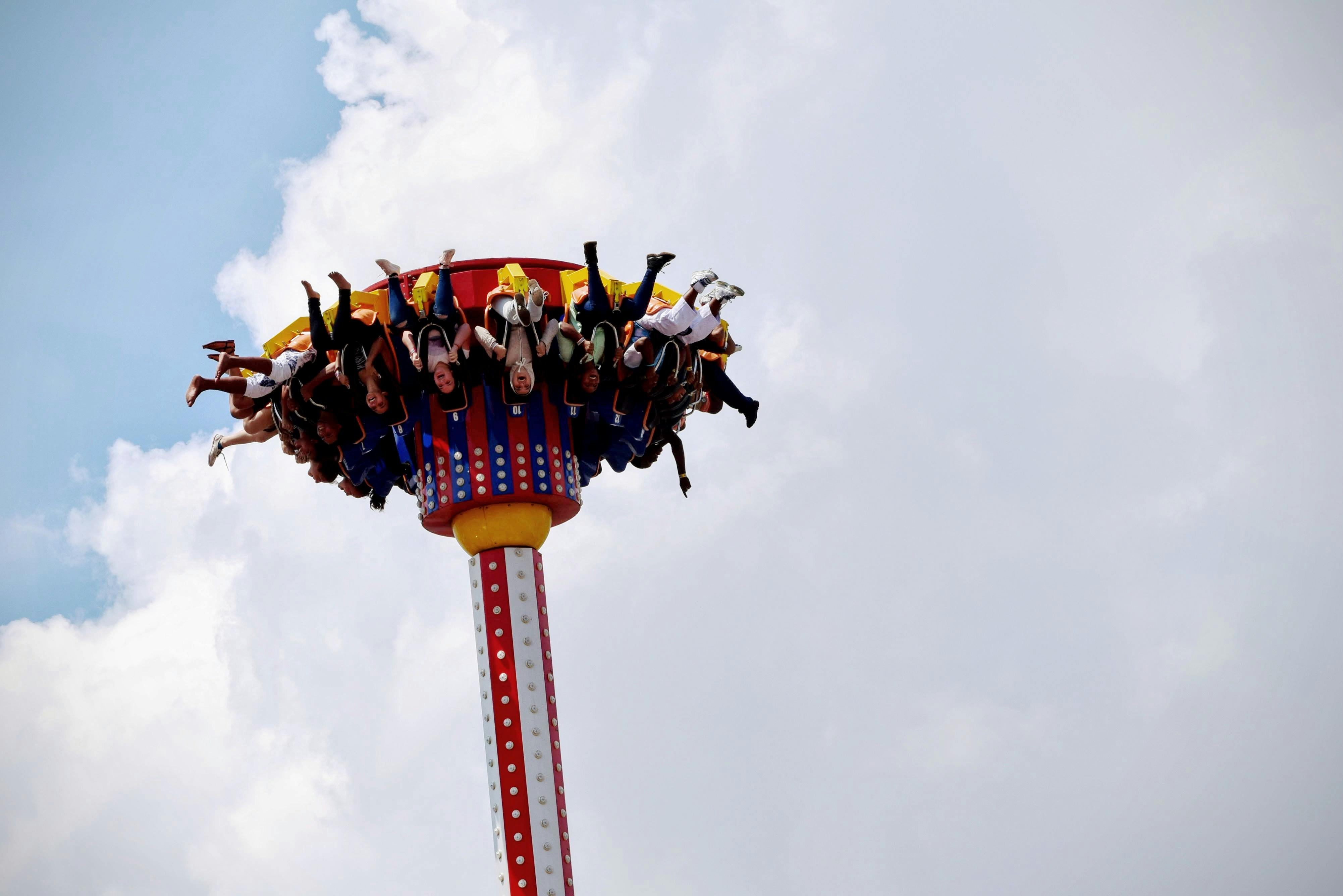 People Riding on White and Red Carnival Rides