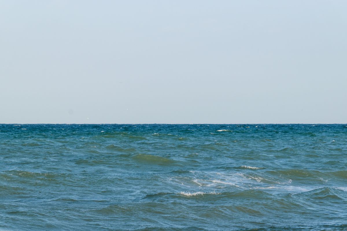 海に浮かぶ帆船と島影のイメージ