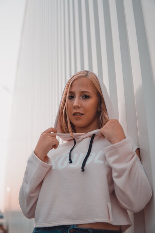 Free Woman In Pullover Hoodie Leaning On Wall Stock Photo