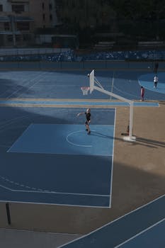 Aerial shot of children playing basketball on a court in Paris, showcasing urban youth sports.