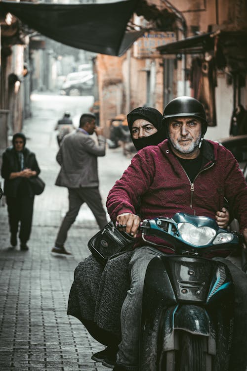 Eldery Man and Woman Riding a Motorcycle in a City 