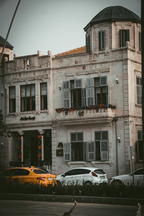 A White Concrete Building Near a Street with Cars