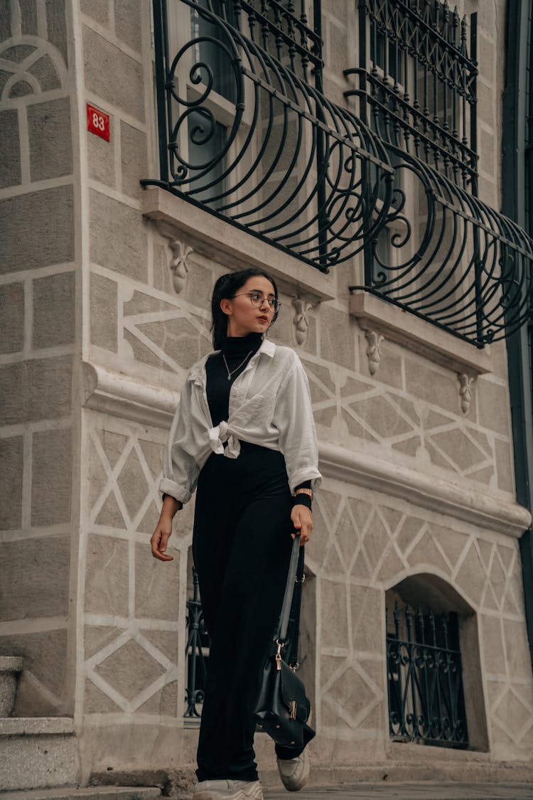 A Woman Walking On The Street While Looking Over Shoulder