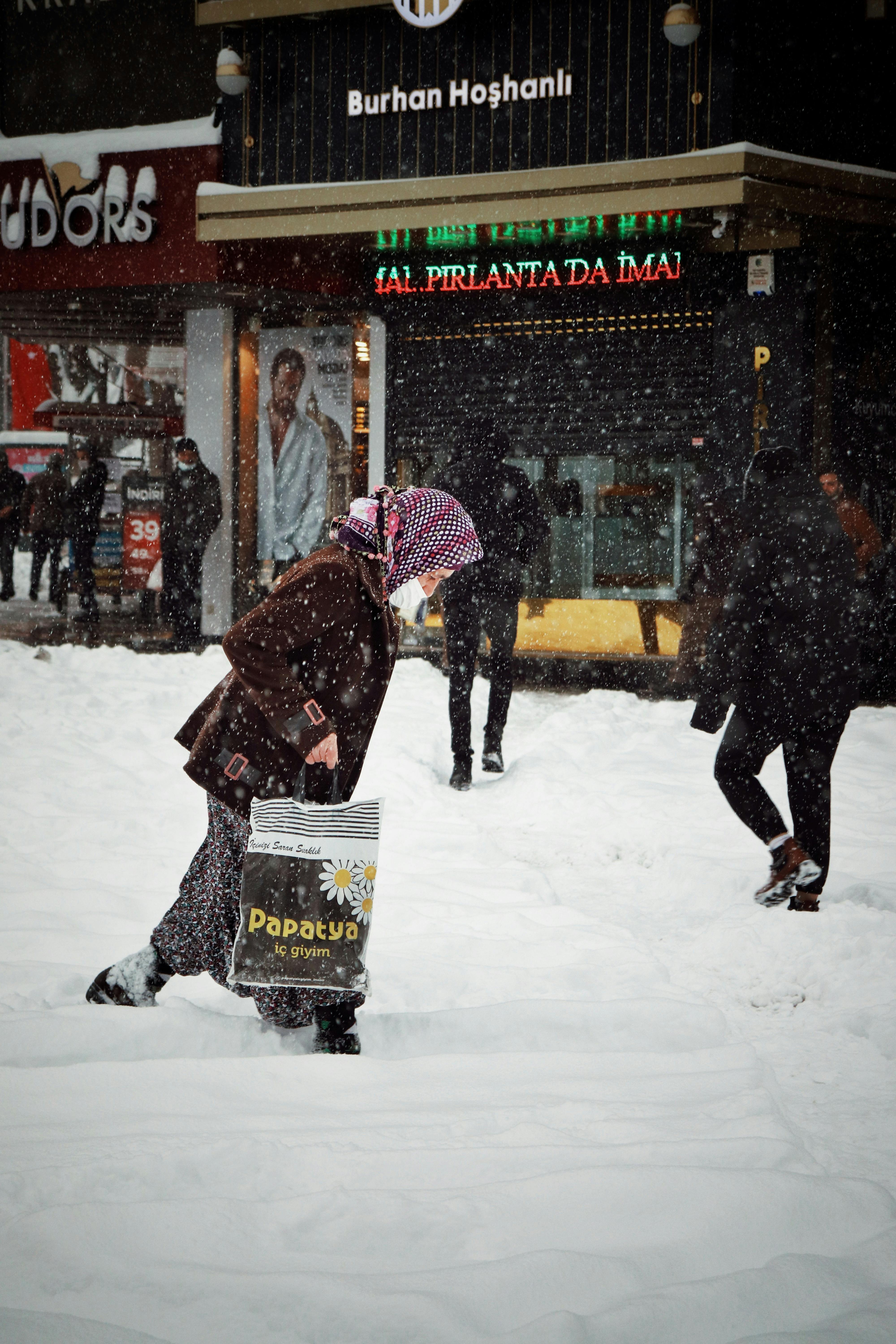 Snowfall in Malatya with people walking on a snowy street, evoking winter's chill.