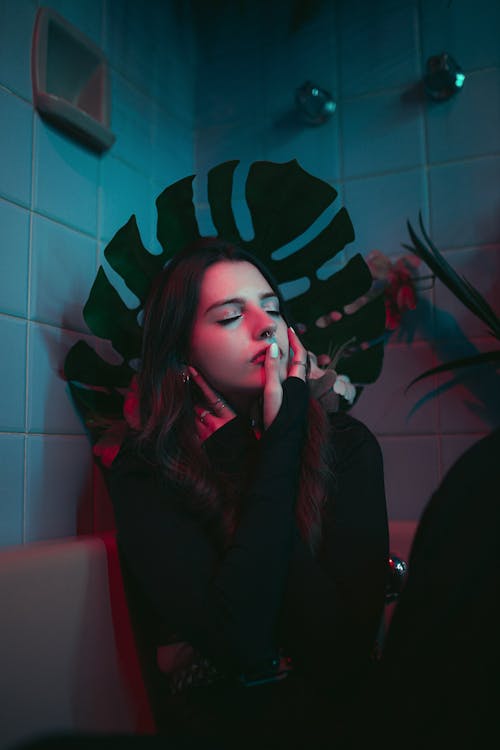 Beautiful Woman Sitting with a Large Leaf Behind her 