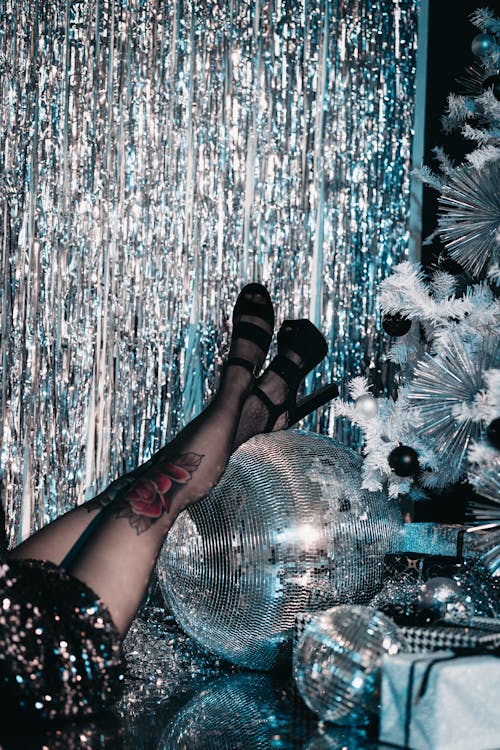 Woman in High Heels Resting Her Legs on a Disco Ball 
