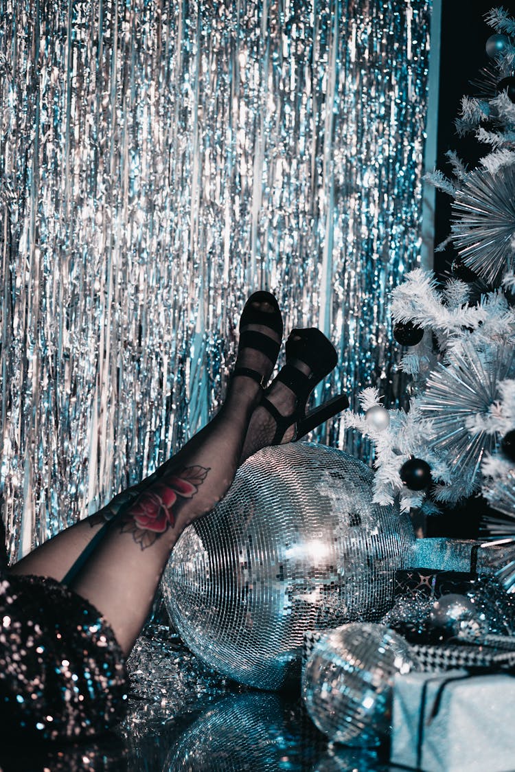 Woman In High Heels Resting Her Legs On A Disco Ball 