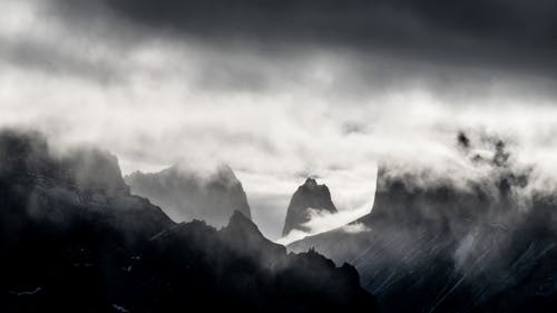 Black and White Photo of Mountain Peaks in a Fog