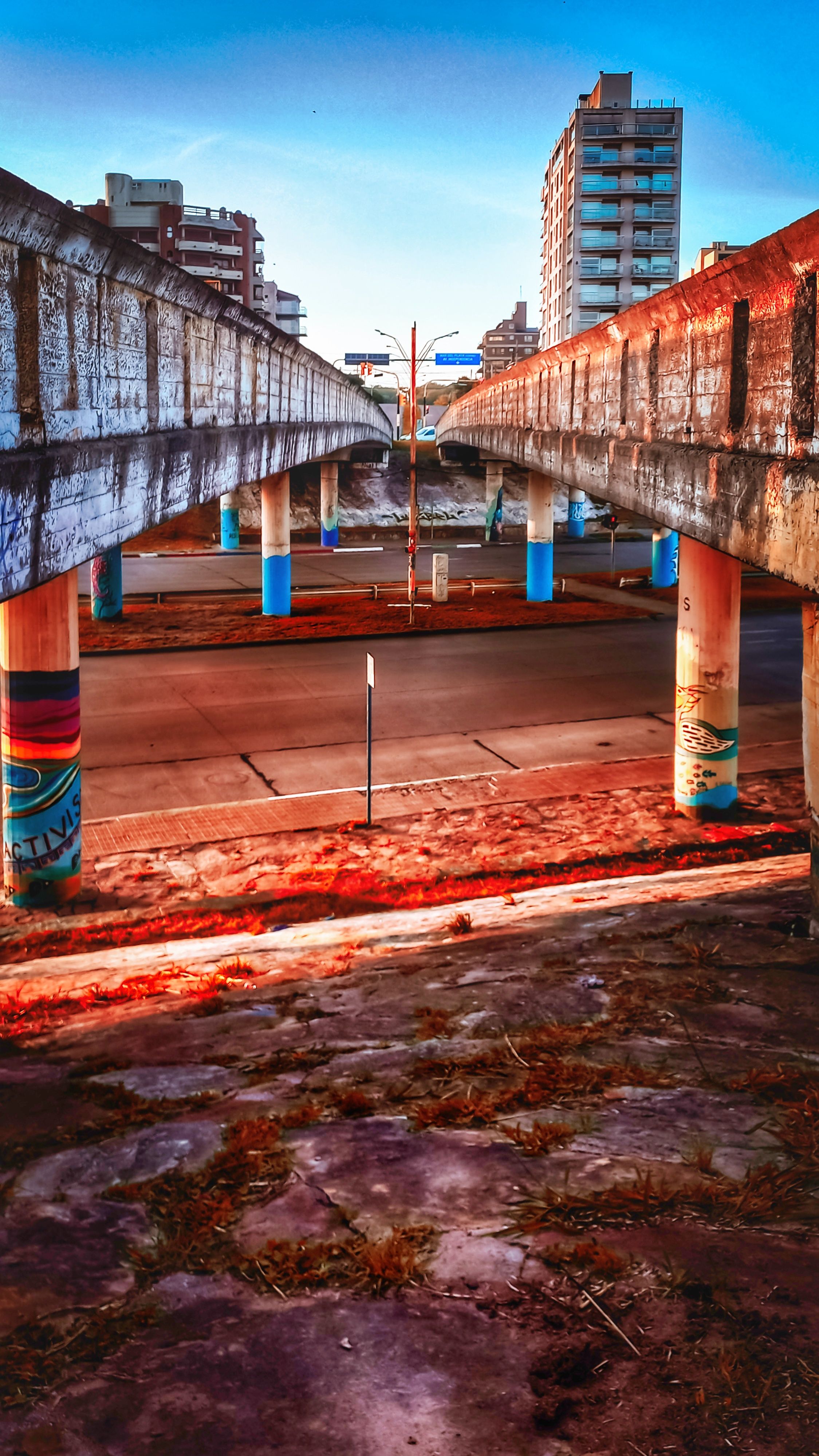 View of urban overpass infrastructure with colorful columns at dusk.