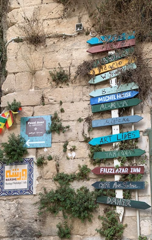 Directional Signs Beside a Stone Wall