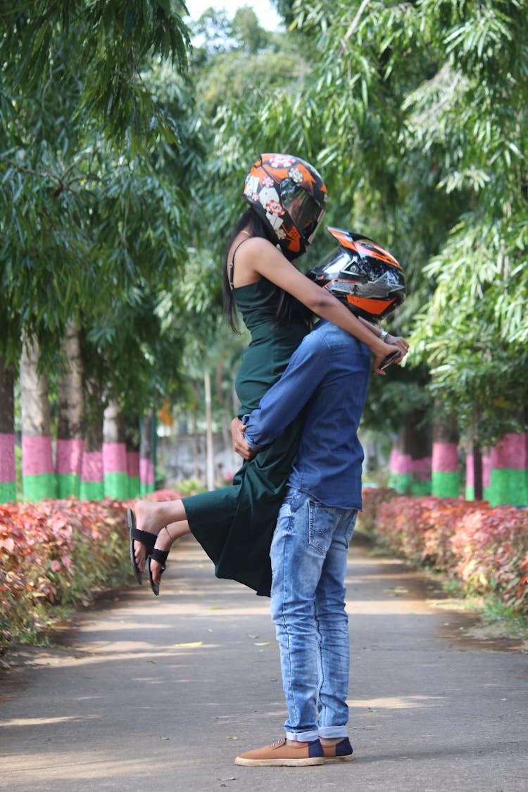 Couple Of Motorcyclists Embracing In Park