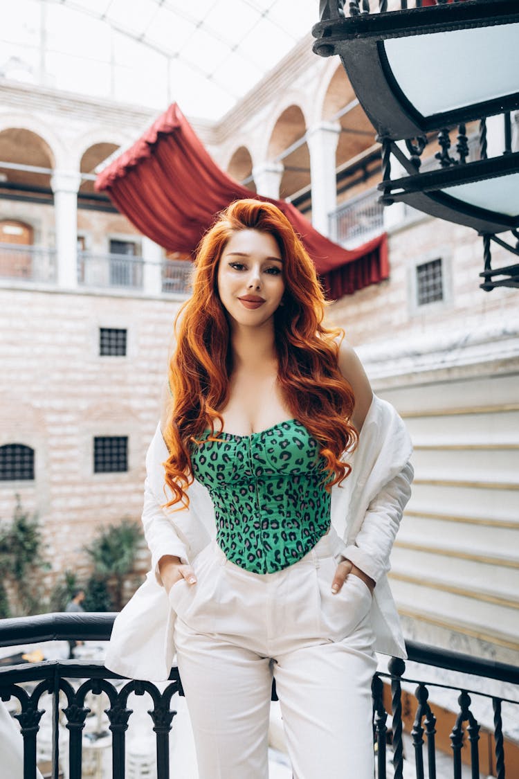 Woman In Teal Leopard Print Top And White Pants Smiling 