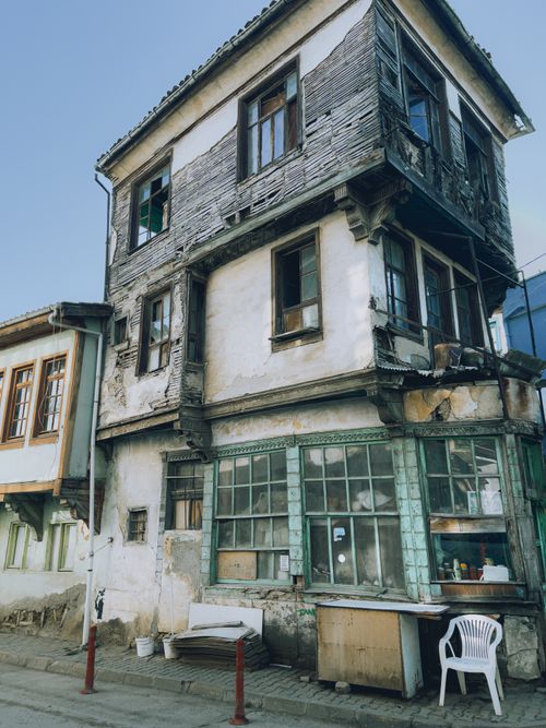 Free Weathered three-story building in an urban setting, showcasing aged architecture and historical charm. Stock Photo