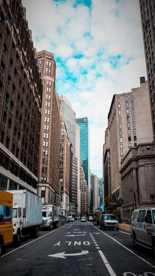 Free Urban street view of New York City with towering skyscrapers and bustling activity. Stock Photo