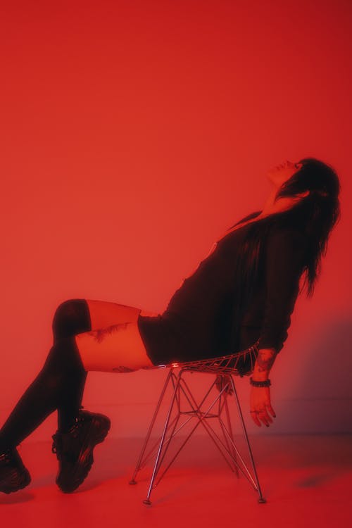 A Woman Sitting on the Chair with Red Lights