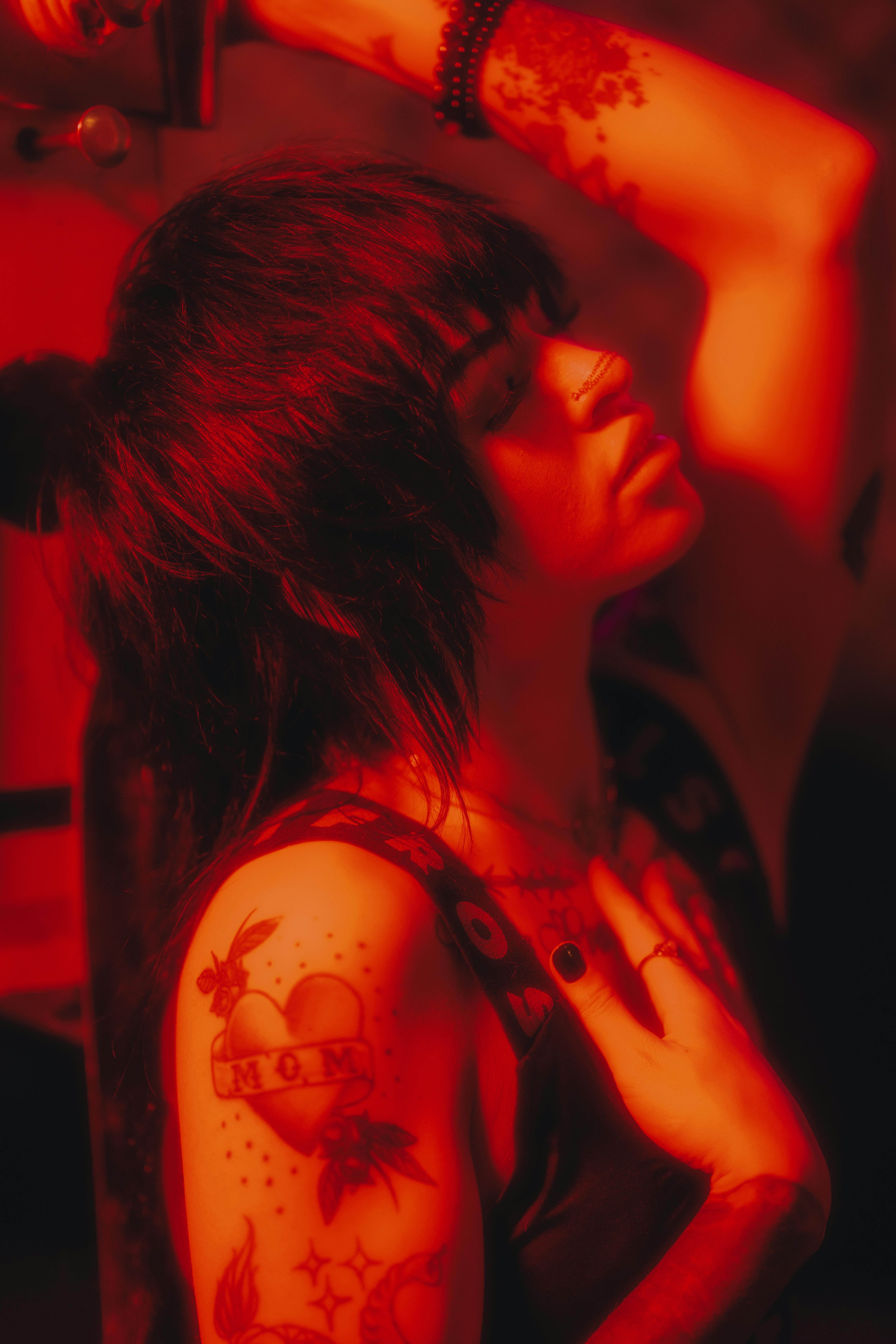 woman with tattoos in red light