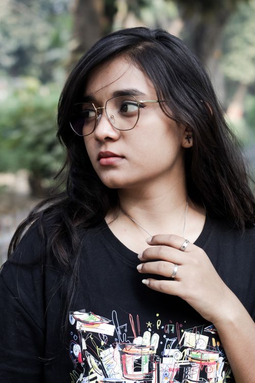 Free Portrait of a young woman with glasses in a casual t-shirt, outdoors in Patna, India. Stock Photo