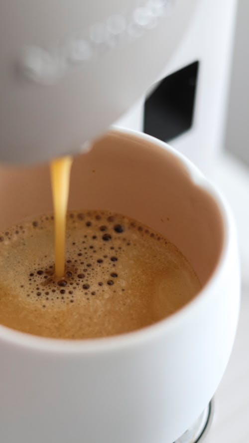 Free Close-up of Coffee Being Poured From a Coffee Machine into a Cup  Stock Photo