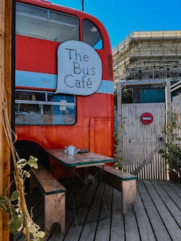 Vintage bus converted into a cozy café with outdoor seating, offering a unique dining experience.