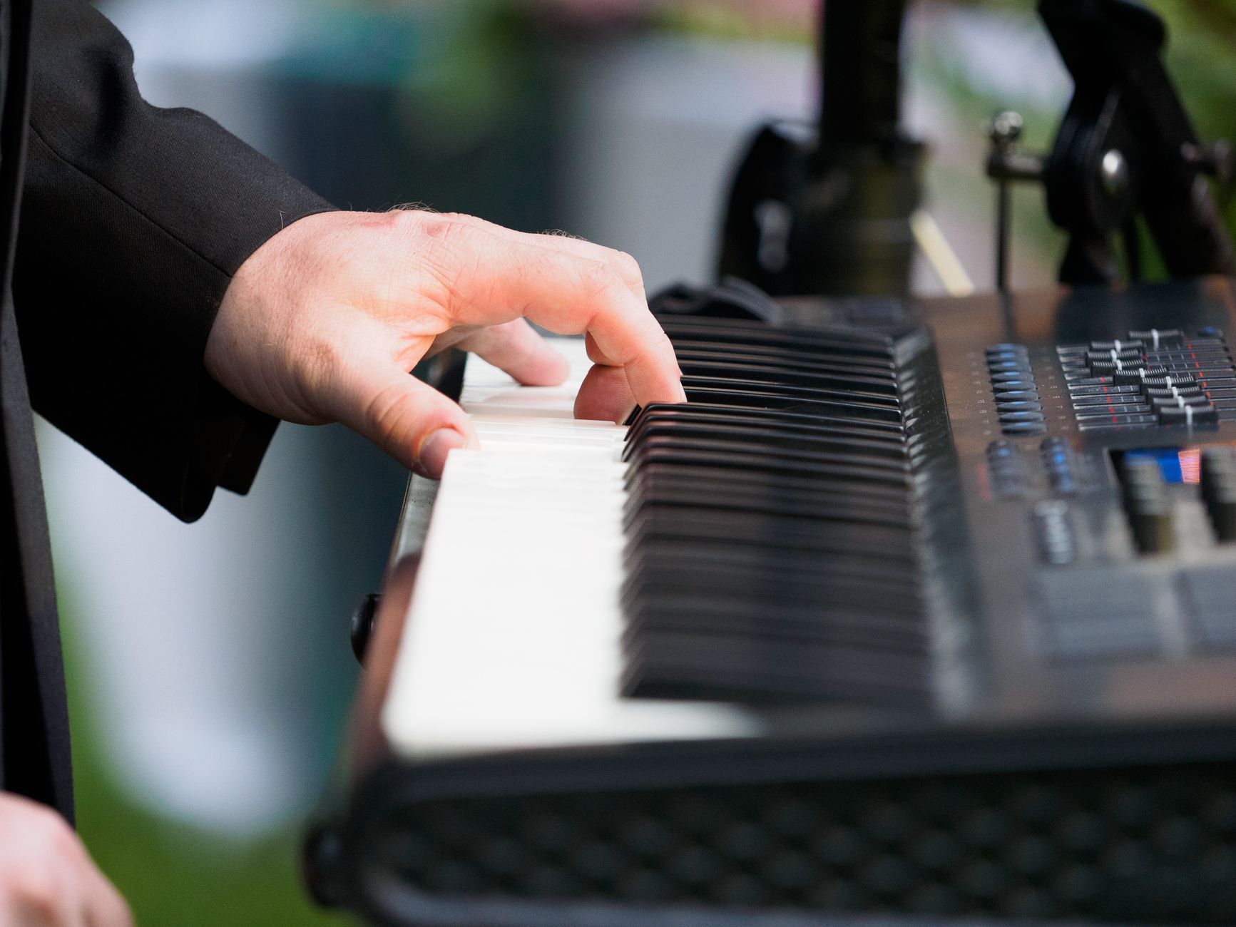 Wedding Ceremony Music Checklist for Every Moment A musician playing keyboard music at an outdoor event