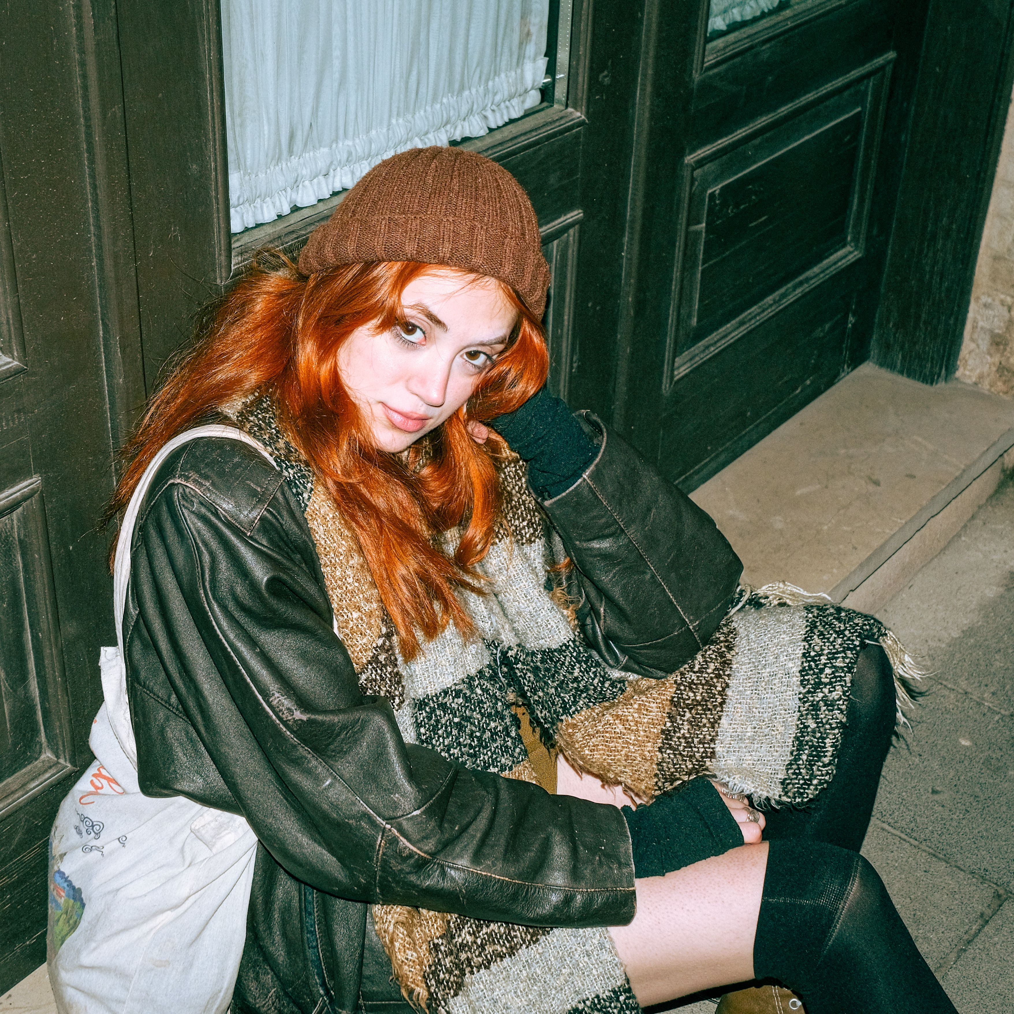 Red Haired Woman with Scarf Sitting on Pavement