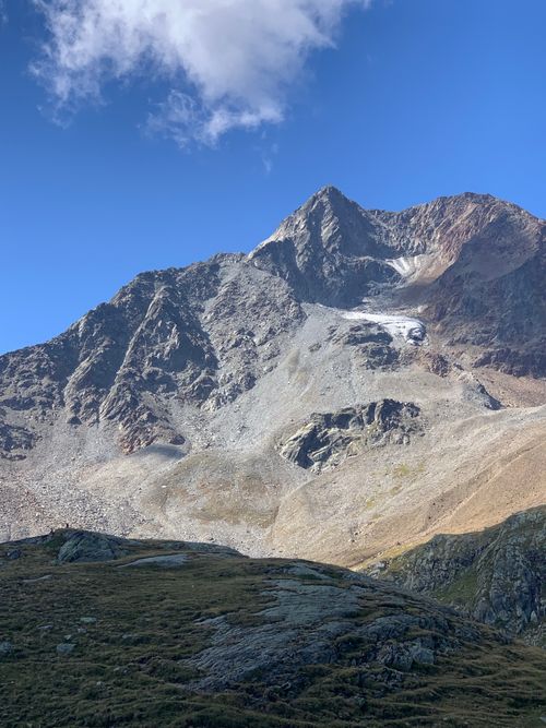 Free A stunning view of a rugged mountain peak against a blue sky with wispy clouds. Stock Photo