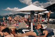 阳光明媚的日子里，俄罗斯索契的海滩上挤满了打着伞的日光浴者