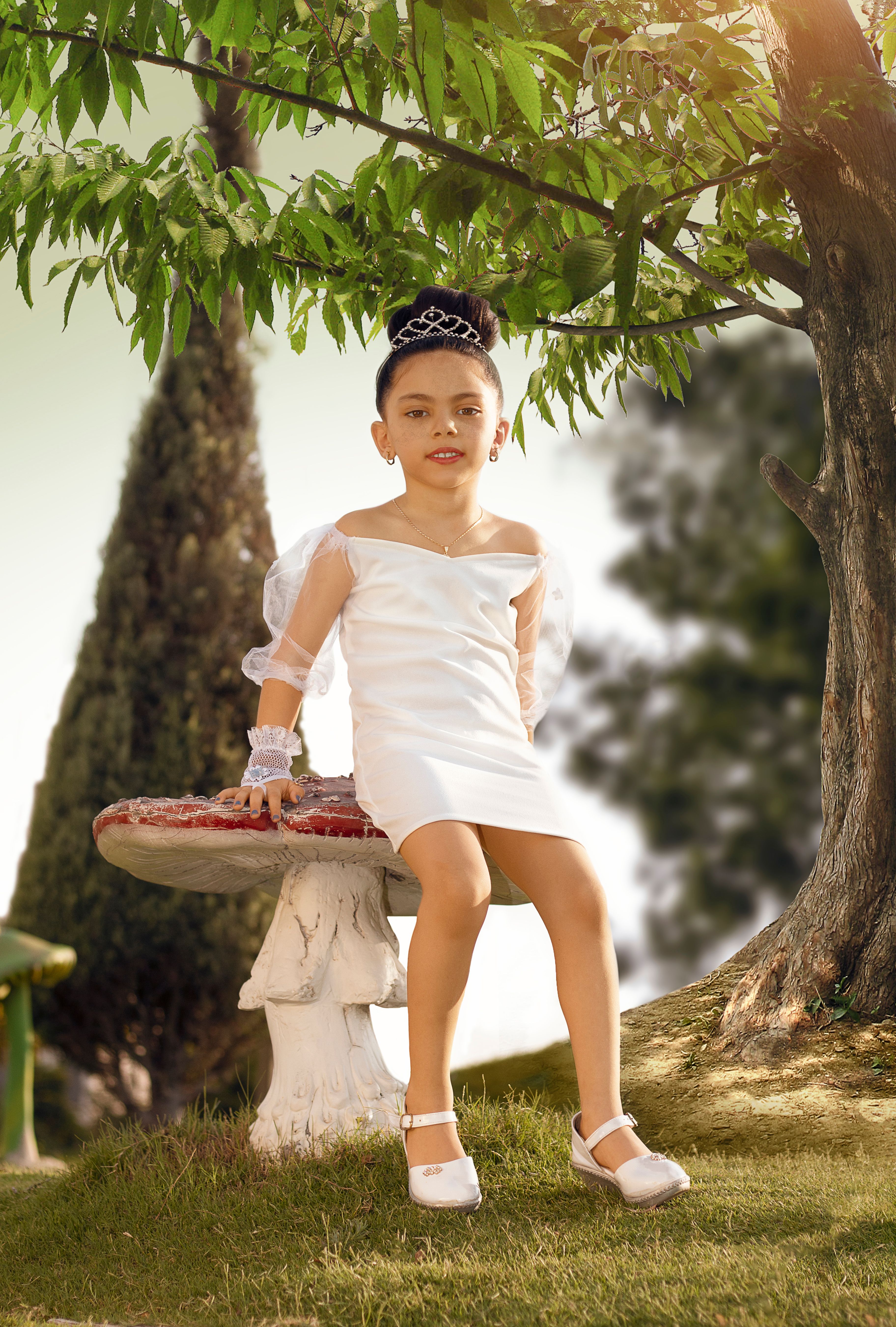 A little girl in a white dress sitting on a bench · Free Stock Photo