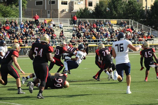Vibrant capture of a live American football game, depicting players in action with a crowd watching eagerly.