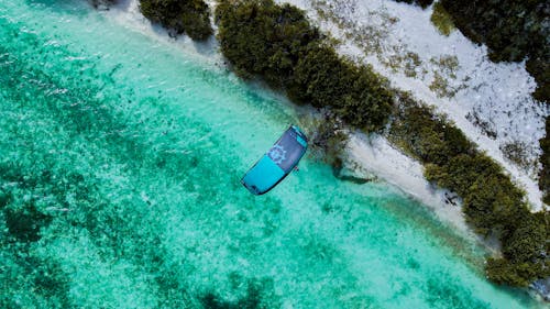 Aerial Footage of a Paraglider Flying over a Turquoise Sea