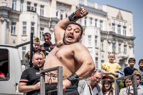 Photo of a Man Hitting a Chain at a Festival