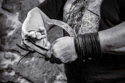 Photo of a Man Bending a Horseshoe