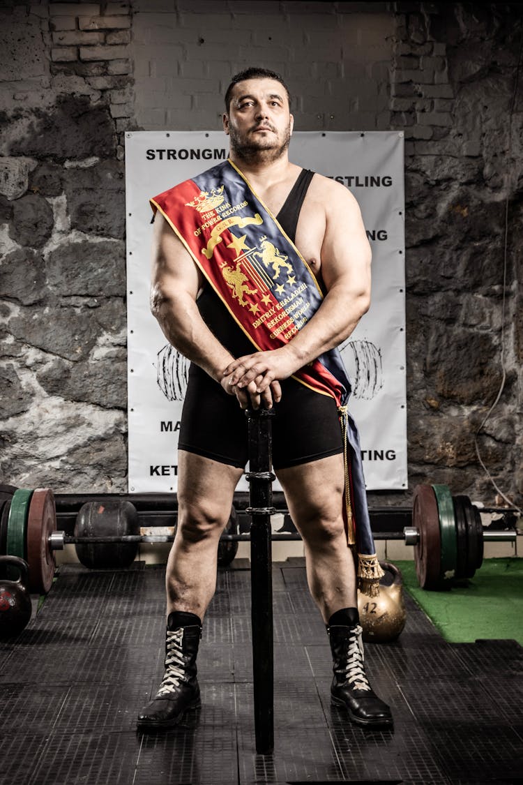 Photo Of A Standing Strong Man In The Gym