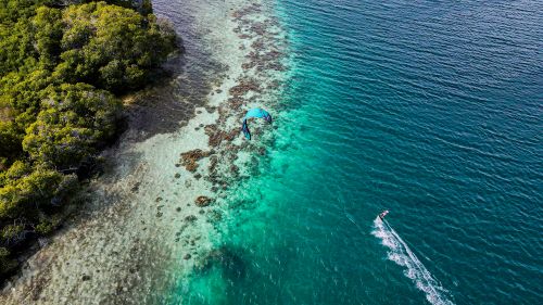 Free Stunning aerial shot of turquoise Caribbean waters, coral reef, and lush coastline in Dependencias Federales, Venezuela. Stock Photo